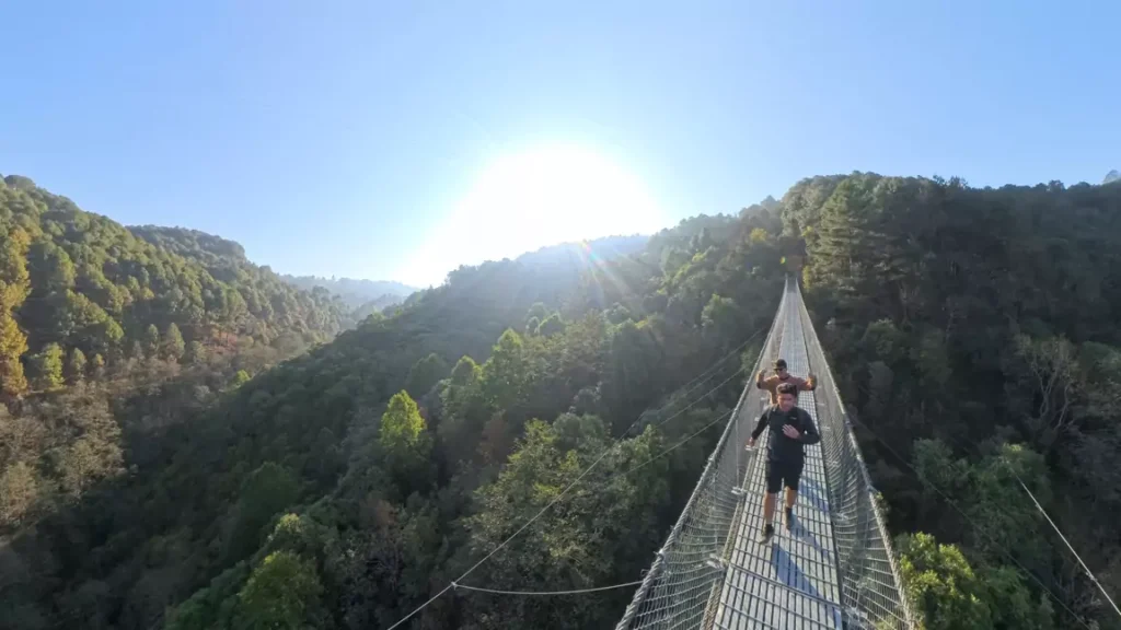 Hiker Hiking through suspension bridge towards Nagarkot