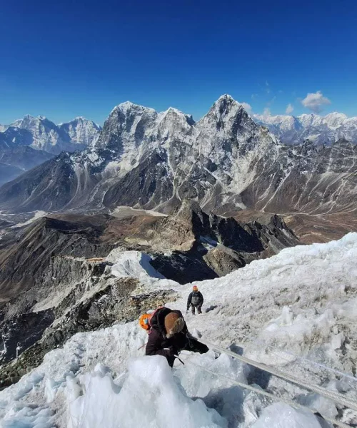 Trekker climbing Lobuche Peak with rope support against a backdrop of snowy mountain terrain Trekker climbing Lobuche Peak with rope support against a backdrop of snowy mountain terrain